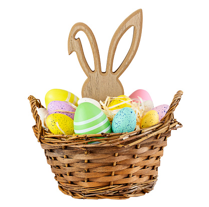Basket with colorful Easter eggs and bunny figure isolated on white