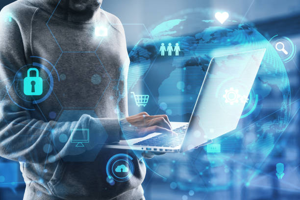istock Hacker using laptop keyboard with glowing globe and business icons hologram on blurry office interior background. Global network, data theft, fishing and data exchange concept. Double exposure. 1457766919