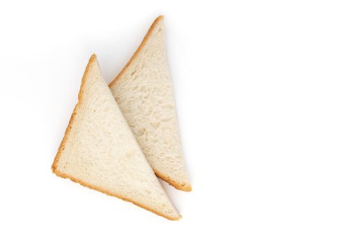 sliced bread cut into triangles isolated on white background, fresh bread for breakfast or lunch, two pieces of bread for sandwich or fried egg