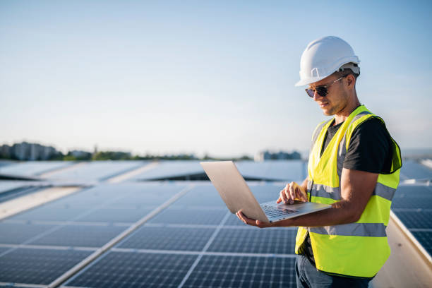 istock Male engineer using laptop at solar photovoltaic power station. 1457768067