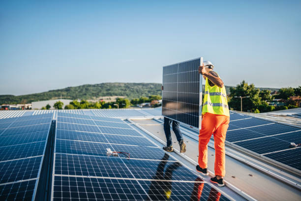 istock Teammates carrying solar panel on a rooftop of a green building. 1457768071