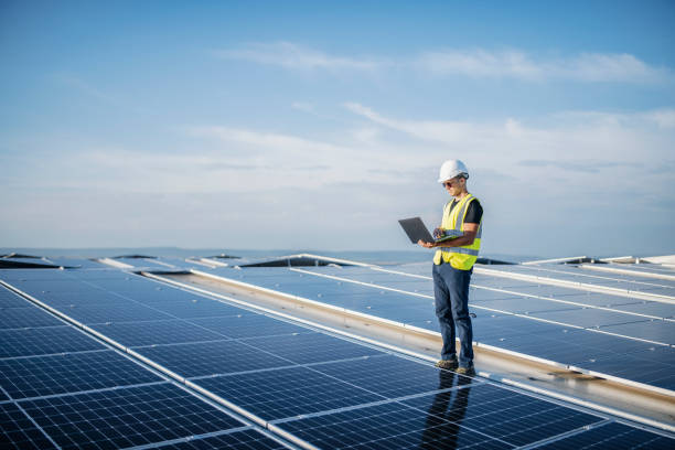 istock Male engineer using laptop at solar photovoltaic power station. 1457768074