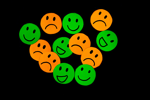 Set of smile and sadness emoticons isolated on black background. Line icons emoticons. Happy and unhappy smileys. Emoji set. Green and orange color.