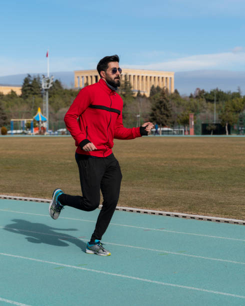 istock young man doing sports on the running track 1457772157