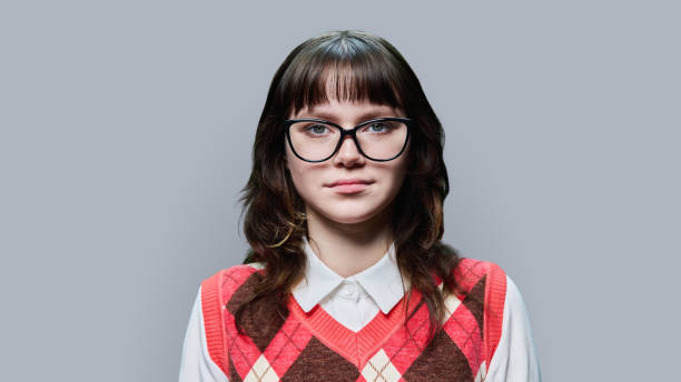 istock Portrait of young female student looking at camera on grey studio background 1457773559