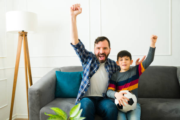 istock Excited father and son enjoying watching the soccer game 1457775457