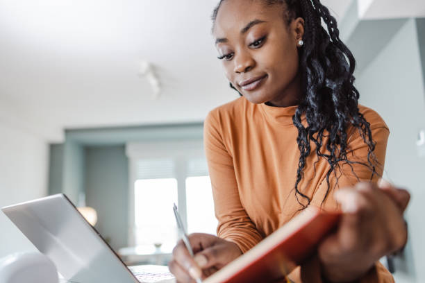 istock Beautiful young woman studying at home 1457775880
