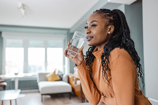 Photo of a young African-American woman drinking water