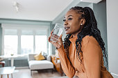 Young woman drinking water at home