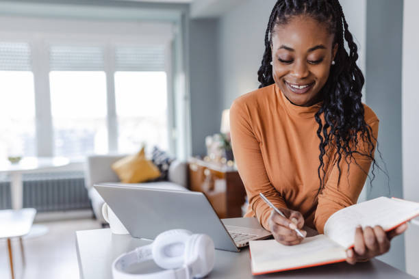 istock Smiling woman studying at home 1457776631