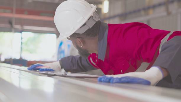 istock Close up.African American industrial engineer or technician wear personal protective equipment, monitor production line process of assembly part, inspect specification of products that come out of machines in production process in manufacturing factory. 1457777997