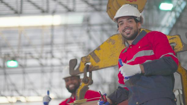 istock Portrait of two expert industrial engineer or technician have confidence and leadership, walking and standing in manufacturing factory. Worker or foreman wear personal protective equipment, thumbs up, crossed arms smiling and look at the camera. 1457778005