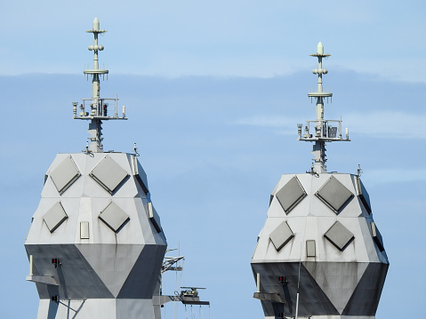 Communication towers of HMAS Warramunga (left) and HMAS Arunta (right).  They are Anzac Class frigates of the Royal Australian Navy docked side-by-side at the Garden Island Naval Base in Sydney Harbour.  This image was taken from Mrs Macquarie's Chair in the afternoon of 14 January 2023.