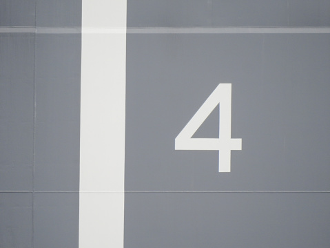 Painted stripe and number on the superstructure next to the flight deck of HMAS Adelaide docked at Garden Island Naval Base, Sydney Harbour.  She is one of two Canberra-class Amphibious Assault Ships of the Royal Australian Navy.  This image was taken from Mrs Macquarie's Chair on the afternoon of 14 January 2023.
