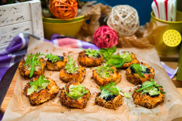 Baked sweet potato bites appetizer with quinoa seeds and ruccola leaves on top stock photo