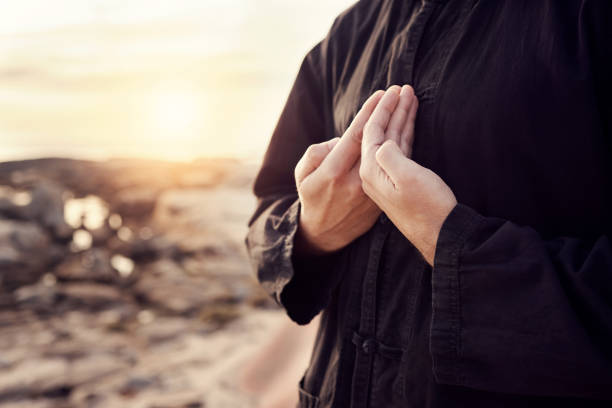 Man, hands or tai chi on sunset beach for relax exercise, workout or training for mental health, chakra balance or mind wellness. Zoom, person or martial arts by sea, ocean or nature water at sunrise hombre, manos o tai chi en la playa al atardecer para hacer ejercicio de relajación, entrenamiento o entrenamiento para la salud mental, el equilibrio de los chakras o el bienestar mental. zoom, persona o artes marciales por mar, océano o agua natural al