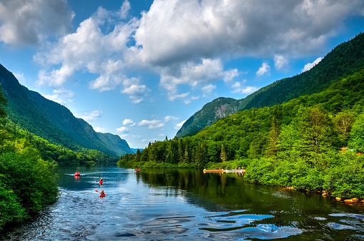 Adventurous people rafting Jacques Cartier river on a perfect sunny summer day, Quebec, Canada