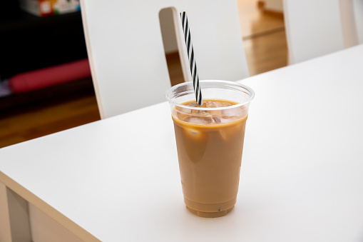 A Ice coffeee with milk and ice cubes on white table