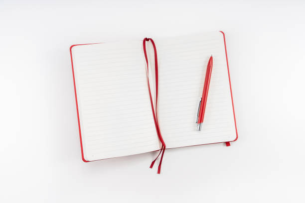 Red notebook with a pen isolated on white stock photo