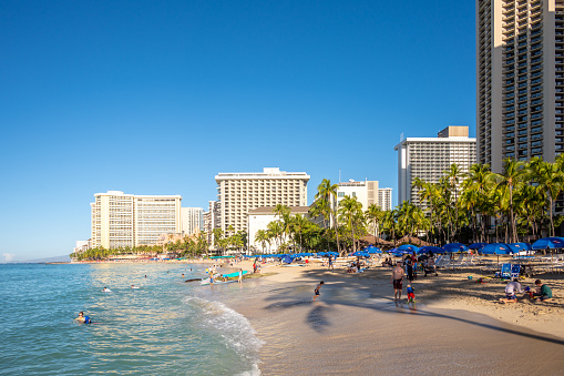 Honolulu, Hawaii - December 26, 2022: Views along famous Waikiki Beach as surfers head out for the day.