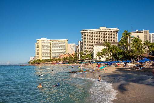 Honolulu, Hawaii - December 26, 2022: Views along famous Waikiki Beach as surfers head out for the day.