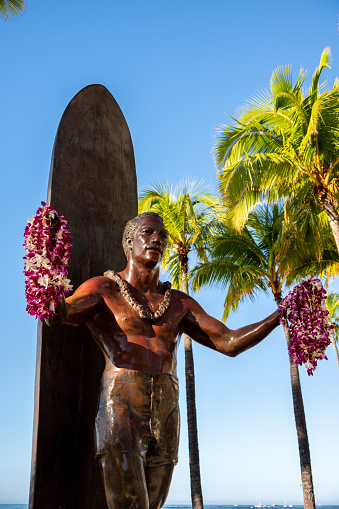 Honolulu, Hawaii - December 26, 2022: Duke Kahanamoku statue in front of Kuhio Beach Park in Waikiki was a Native Hawaiian competition swimmer who popularized the ancient Hawaiian sport of surfing