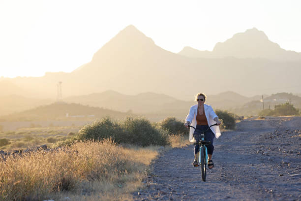 Solo man mountain biking on extreme desert badlands landscape terrain as the sunset light skips across the scenery in golden hues.  Such beautiful nature scenery and outdoor sports and wellness can found while riding the White Ridge trails of central New Mexico, USA.