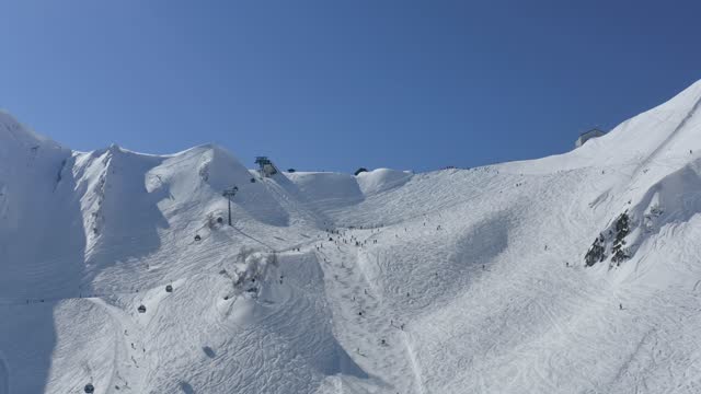 Aerial view skiers snowboard tourist riding downhill on slope winter ski resort