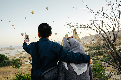Senior couple enjoy the sunrise with view of  hot balloon in goreme