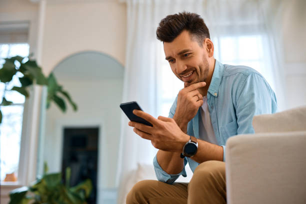 istock Happy man reading text message on cell phone at home. 1457799336