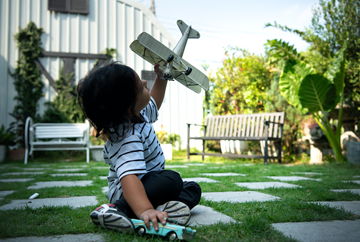 Portrait of a little boy in the front yard. with model aircraft which is the dream of a child who wants to be a pilot.