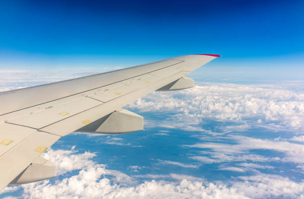istock View from the airplane window at a beautiful cloudy sky and the airplane wing 1457803700