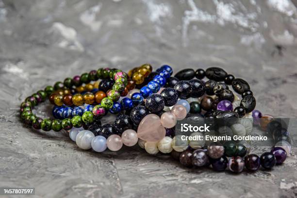 Bracelets Made Of Natural Stones Closeup On A Gray Background Many Bracelets Made Of Various Natural Stones Copy The Space Stock Photo - Download Image Now
