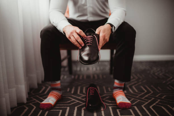 Groom getting shoes on for wedding day