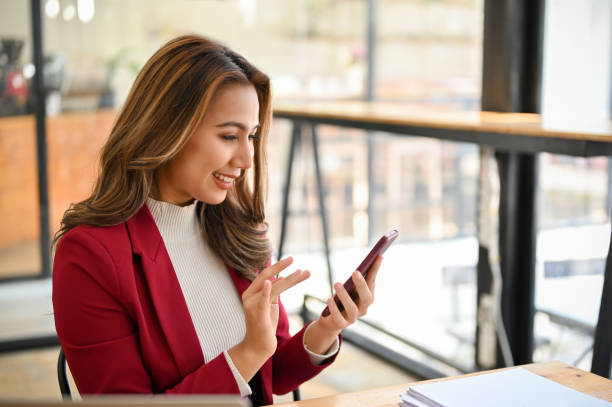 istock Attractive Asian businesswoman chatting with someone, checking schedule, using mobile app 1457809709