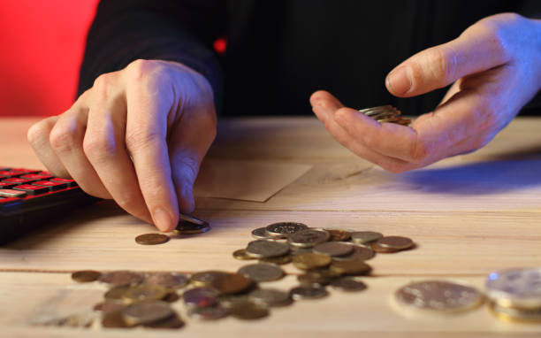 istock counting coins by a person on a table 1457812750