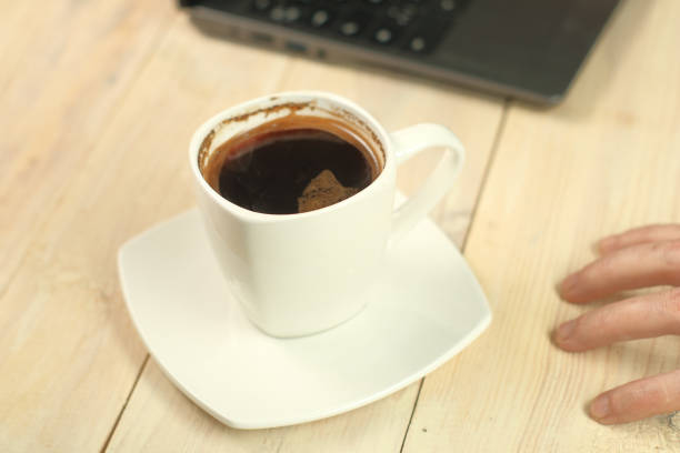 istock a cup with coffee on a stand and a laptop 1457812967