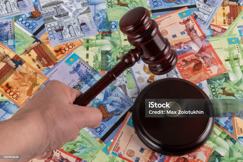Judge's gavel and Kazakhstani coin in denominations of 100 tenge against the background of Kazakhstani tenge Financial Planning Stock Photo