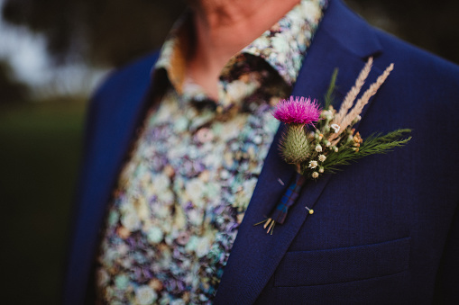 Colorful wedding boutonniere on a blue suit coat
