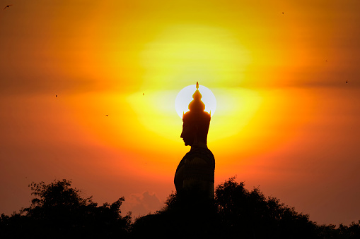 Black silhouette of Buddha statue, Thailand.
