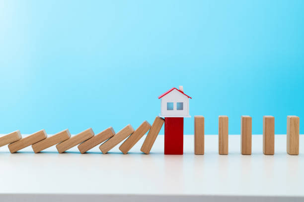 istock Wooden dominos falling to a model house 1457819073