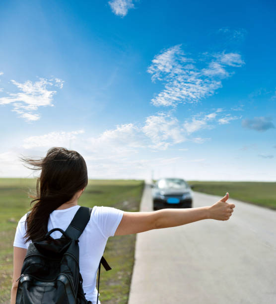 istock Woman standing on roadside with thumb up 1457820308