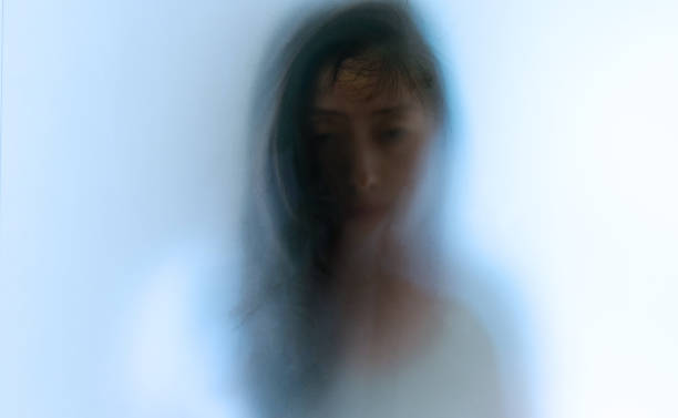 istock Woman face behind frosted glass 1457820385