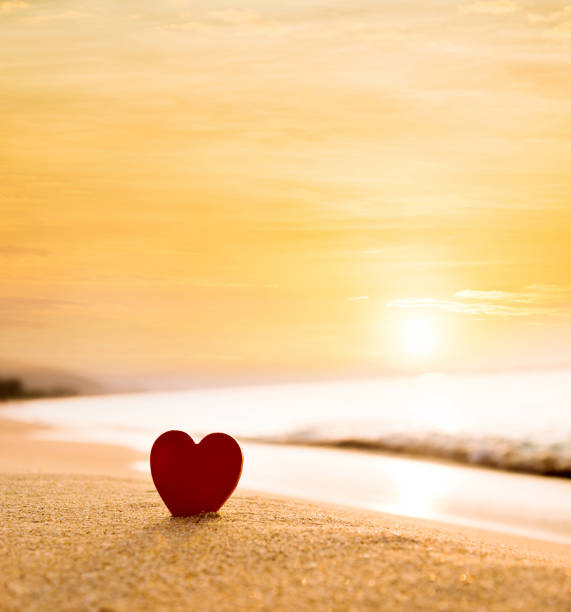 istock Red heart shape on the beach at sunset 1457820513