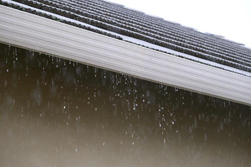 Heavy rain overflowing roof gutter
