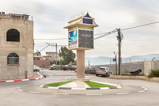 Ghajar, Israel, December 03, 2022 : Square decorated with a large clock on the main street in the Ghajar Alawite Arab village, located on the Golan Heights, on the border with Lebanon, in Israel