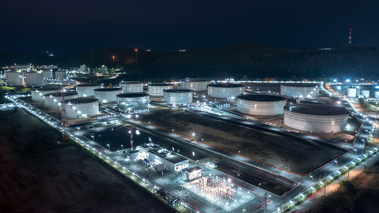 Aerial view of Chemical industry storage tank and oil refinery in Industrial Plant at night over lighting, Fuel and power generation, petrochemical factory industry zone, pullution and wasted energy concept,