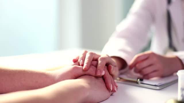 Doctor hand calms patient in clinic closeup