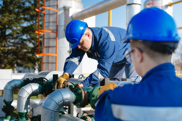 istock Oil worker turning valve on oil rig 1457841101