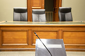 microphone of witnesses inside courtroom with judge and clerks workplace courthouse interior wooden desk justice court